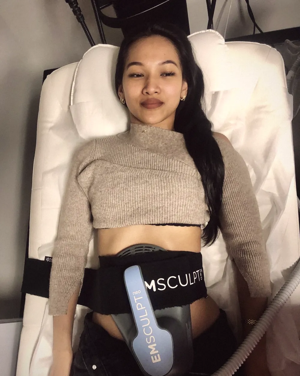 Client relaxing during an Emsculpt Neo session at Rescu