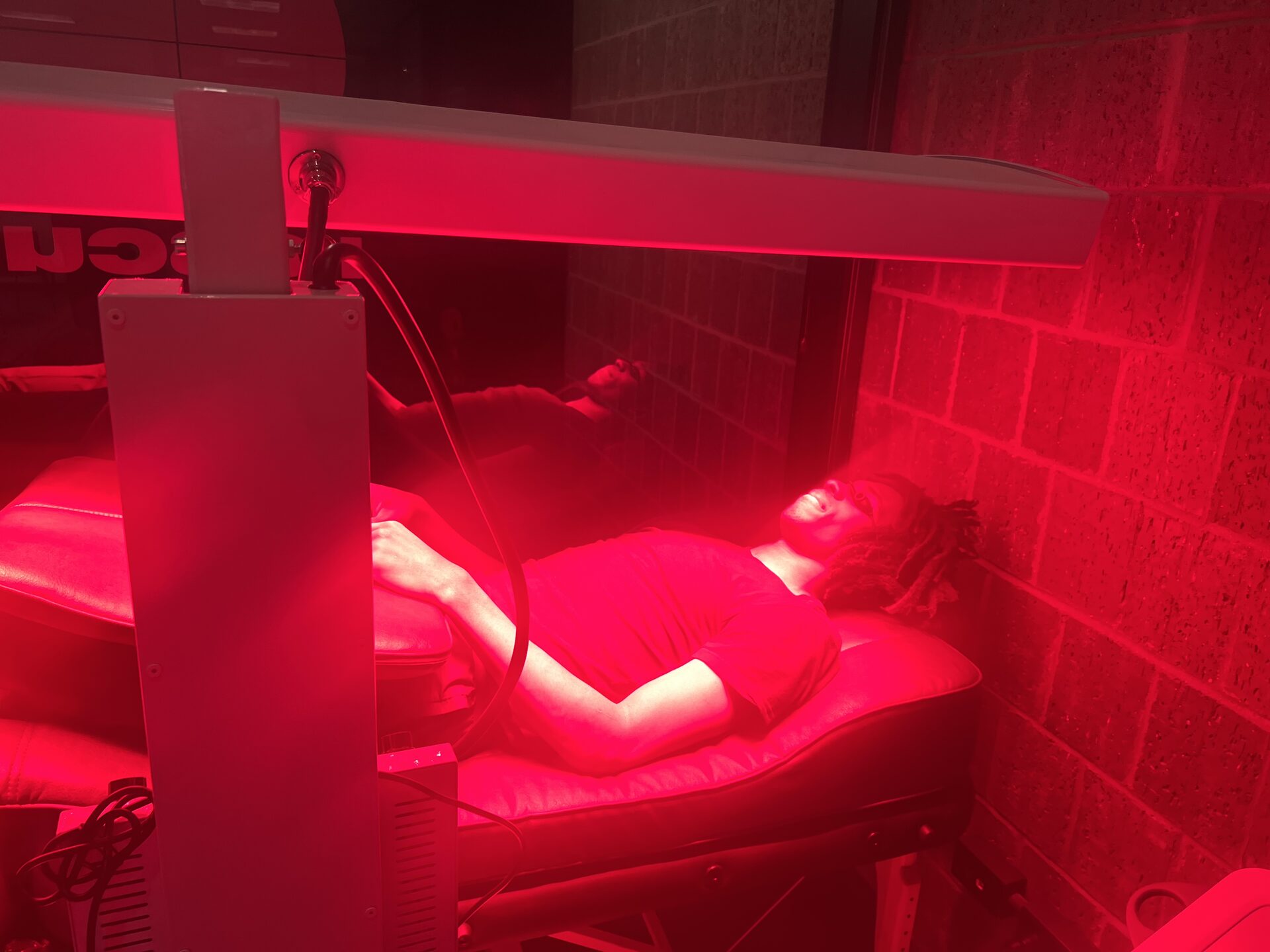 Client under full-body red light panel at Rescu Wellness Westchester