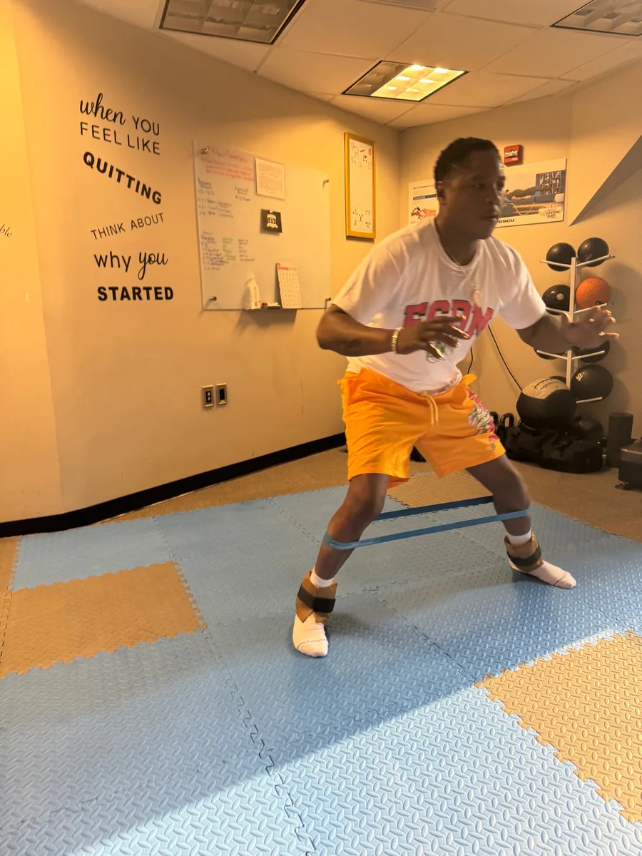 Person in a white Rescu shirt performing a resistance exercise